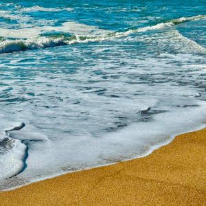 Waves gently washing onto sandy beach.